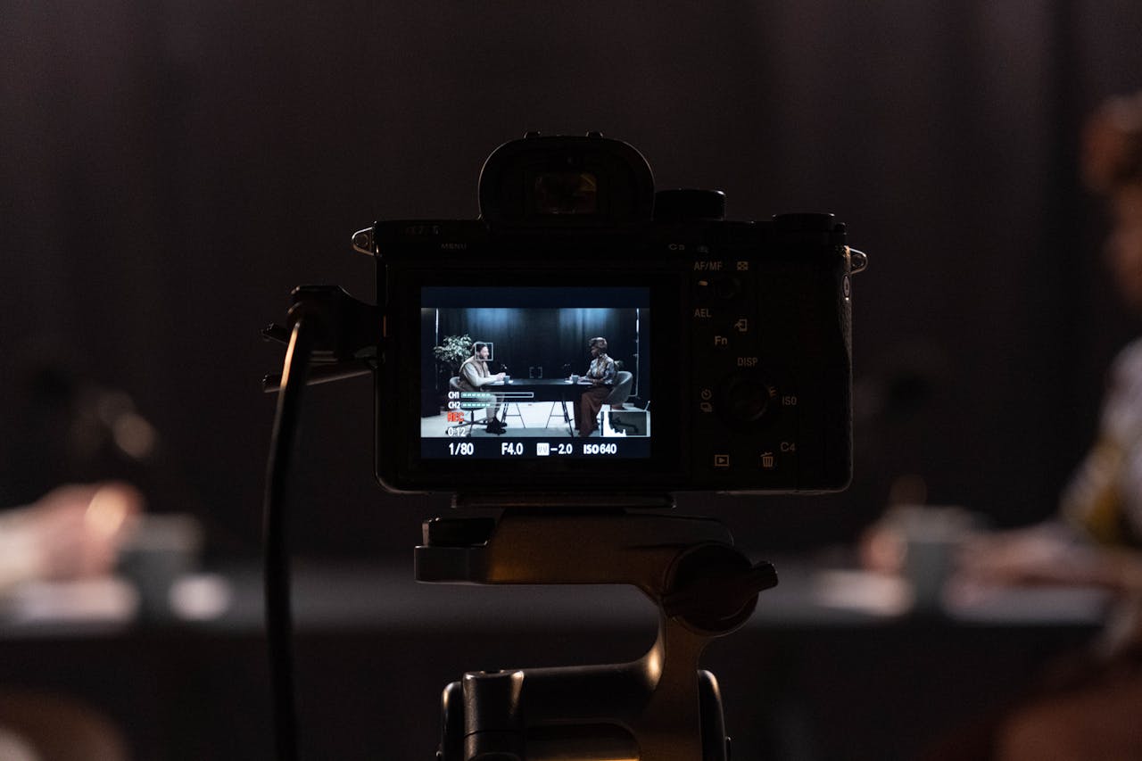 Close-up of a camera recording a podcast interview in a studio setting.